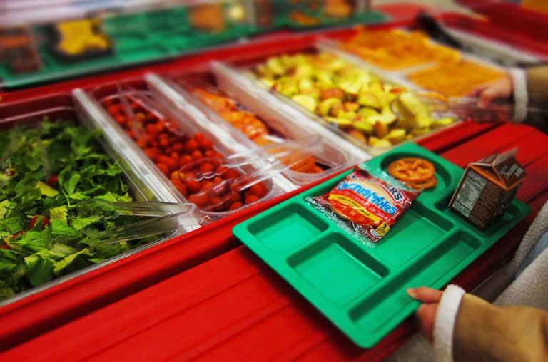 A student getting food from the cafeteria service line 